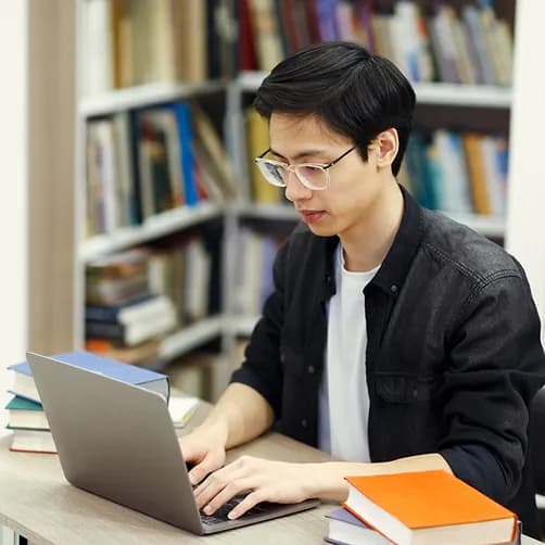 man at a laptop in a library