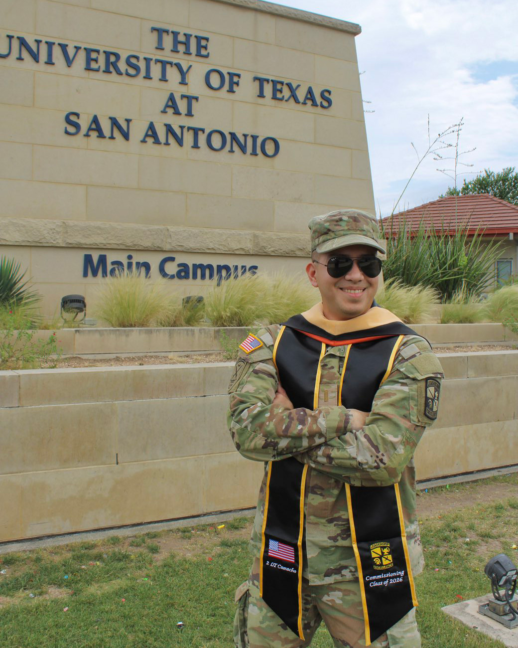 Carlos Camacho stands in front of the university welcome sign at the Main Campus