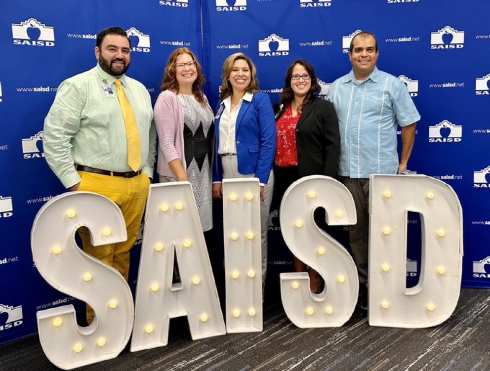 Photo of SAISD Principals with Dr. Juanita Sanos in front of an SAISD sign
