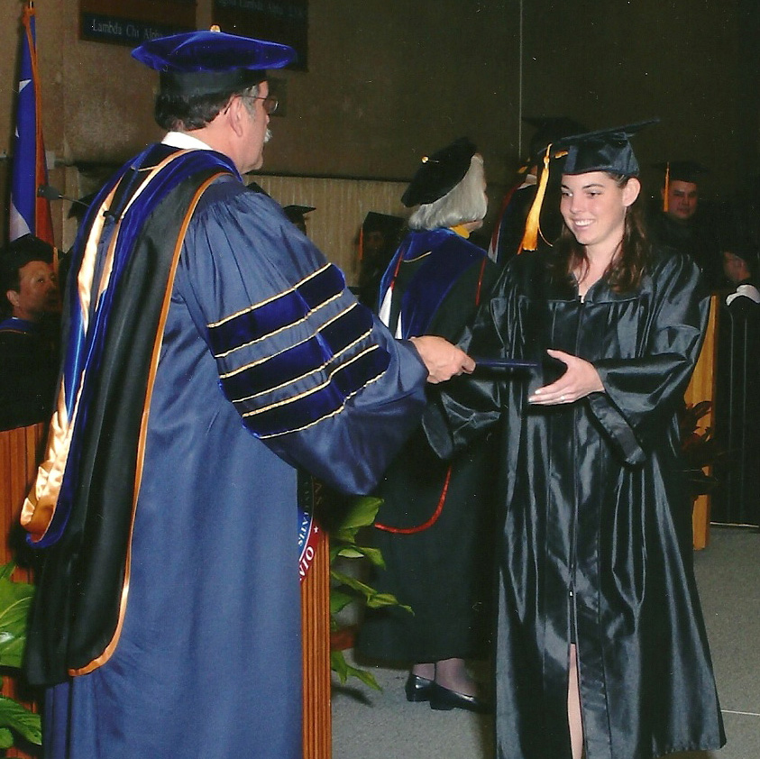 Naomi Rubal crosses the graduation stage to receive her bachelor's degree.