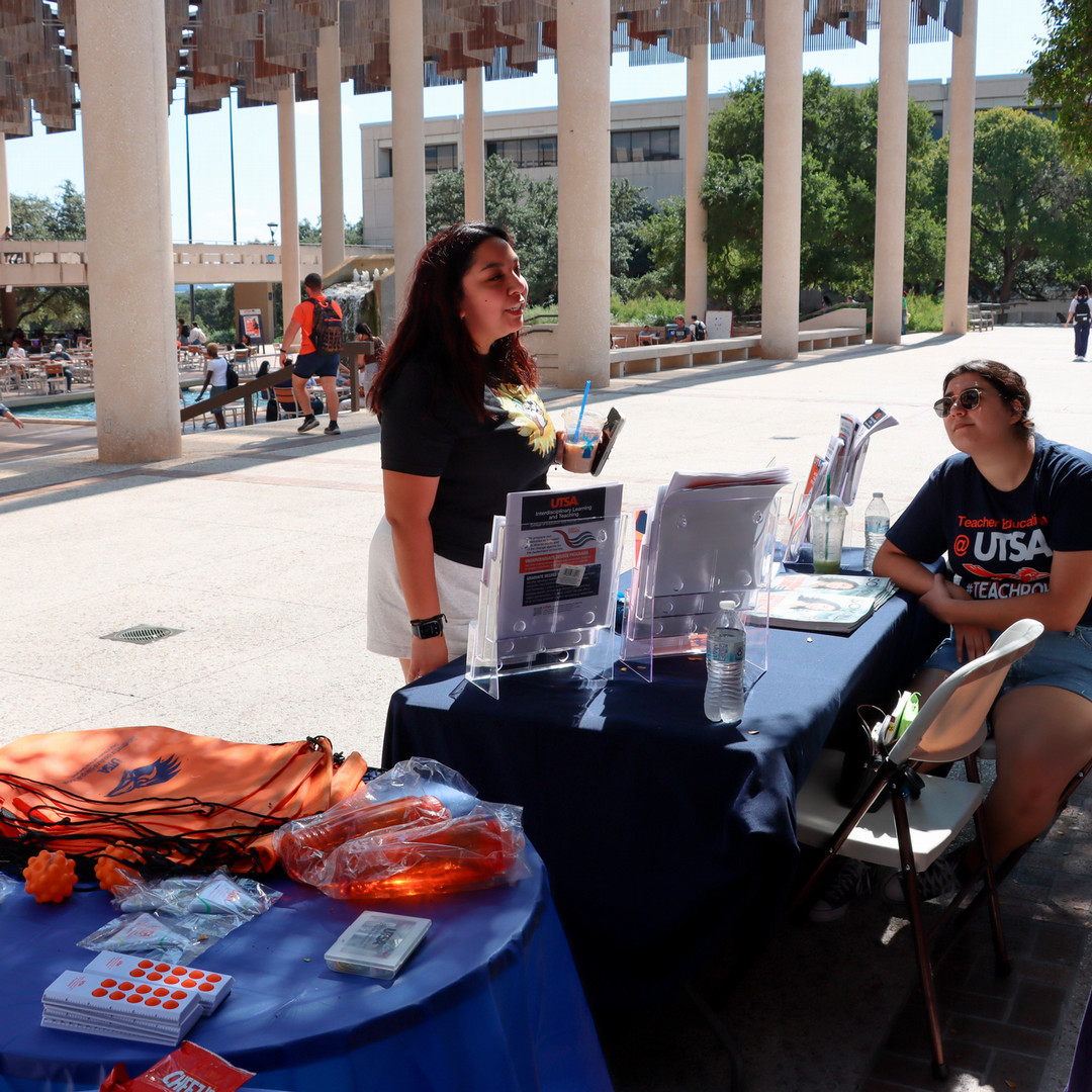 A student talks with COEHD staff at the World Teachers' Day celebration