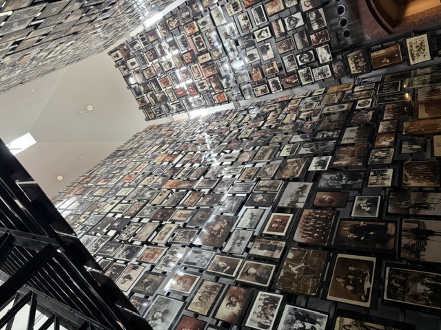 A large museum wall covered with hundreds of framed photographs