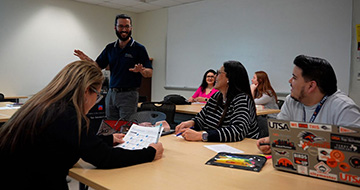 An Alamo Colleges Cohort student walks through the classroom and leads a discussion 