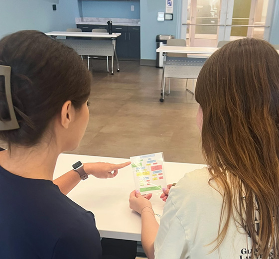 Researcher Kim Cantu-Davis (left) looks at the de-escalation task steps with UTSA graduate student Samantha Perez.