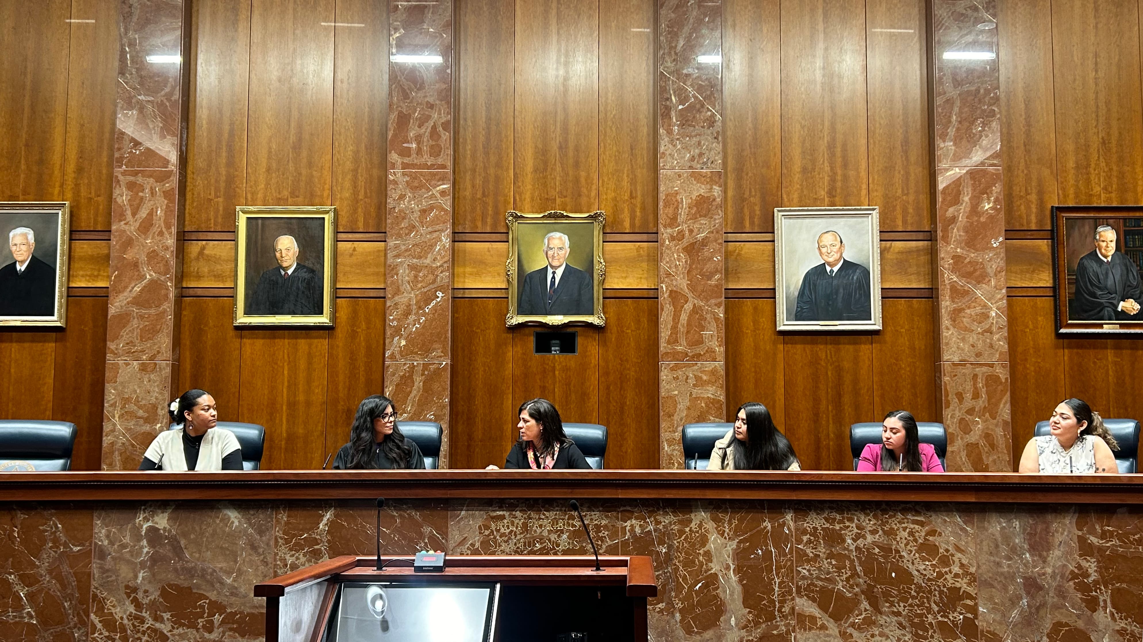 The ELPS research team holds a discussion with Justice Rebecca Huddle on the bench at the Texas Supreme Court.