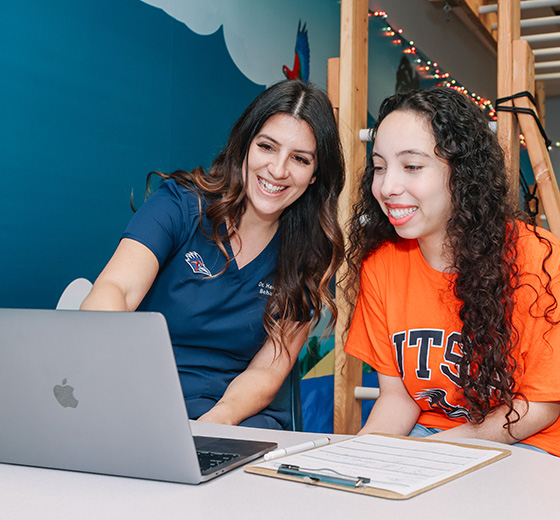 A student and a UTSA Department of Educational Psychology faculty member review materials together at the Downtown Campus.
